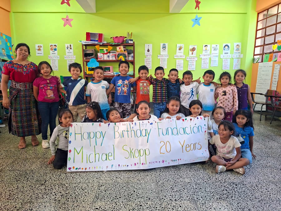 Eine Gruppe von Kindern in Guatemala halten eine Banner mit Geburtstagswünsche für die Stiftung